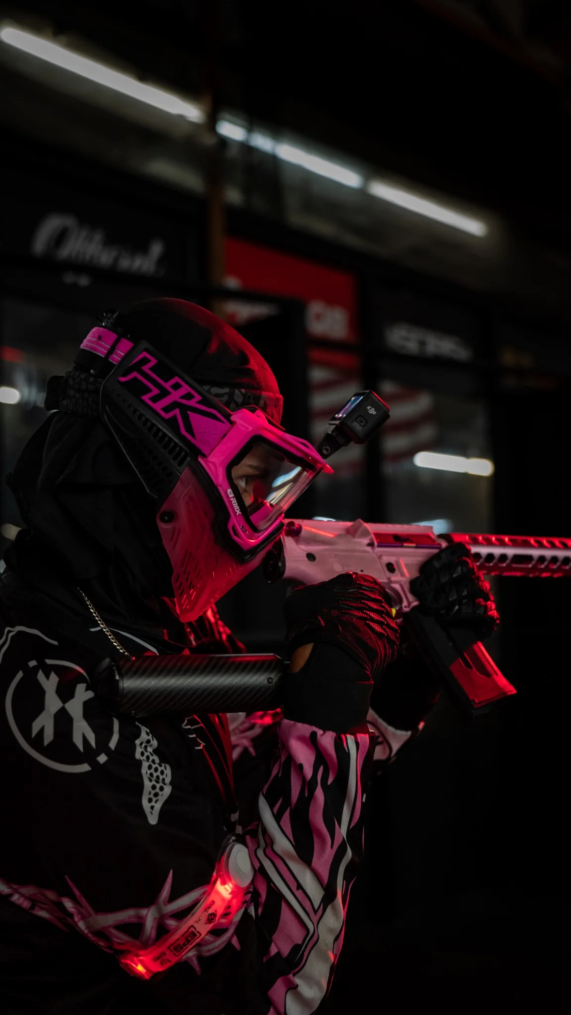 Disciples Airsoft player aiming a pink airsoft replica under red lighting